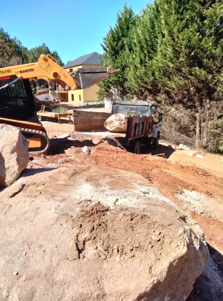 Skid steer loading debris into a dump truck during a property cleanup
