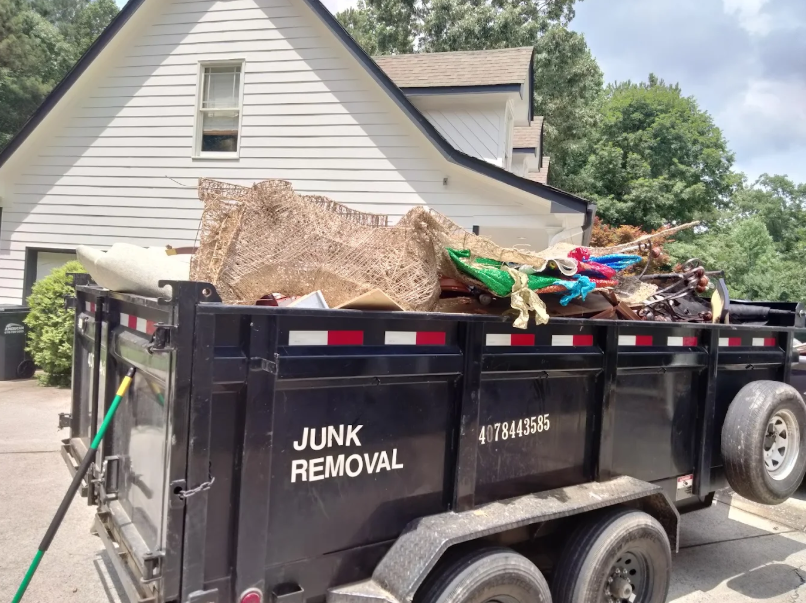 R&J Hauling and Junk Removal crew loading unwanted items into a haul truck