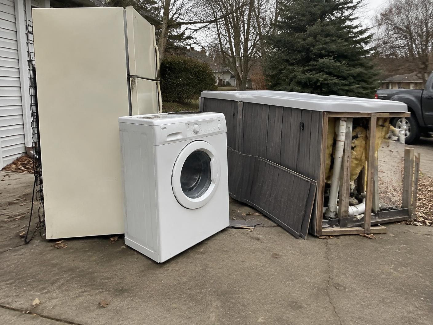 Old refrigerator and washing machine ready for hauling